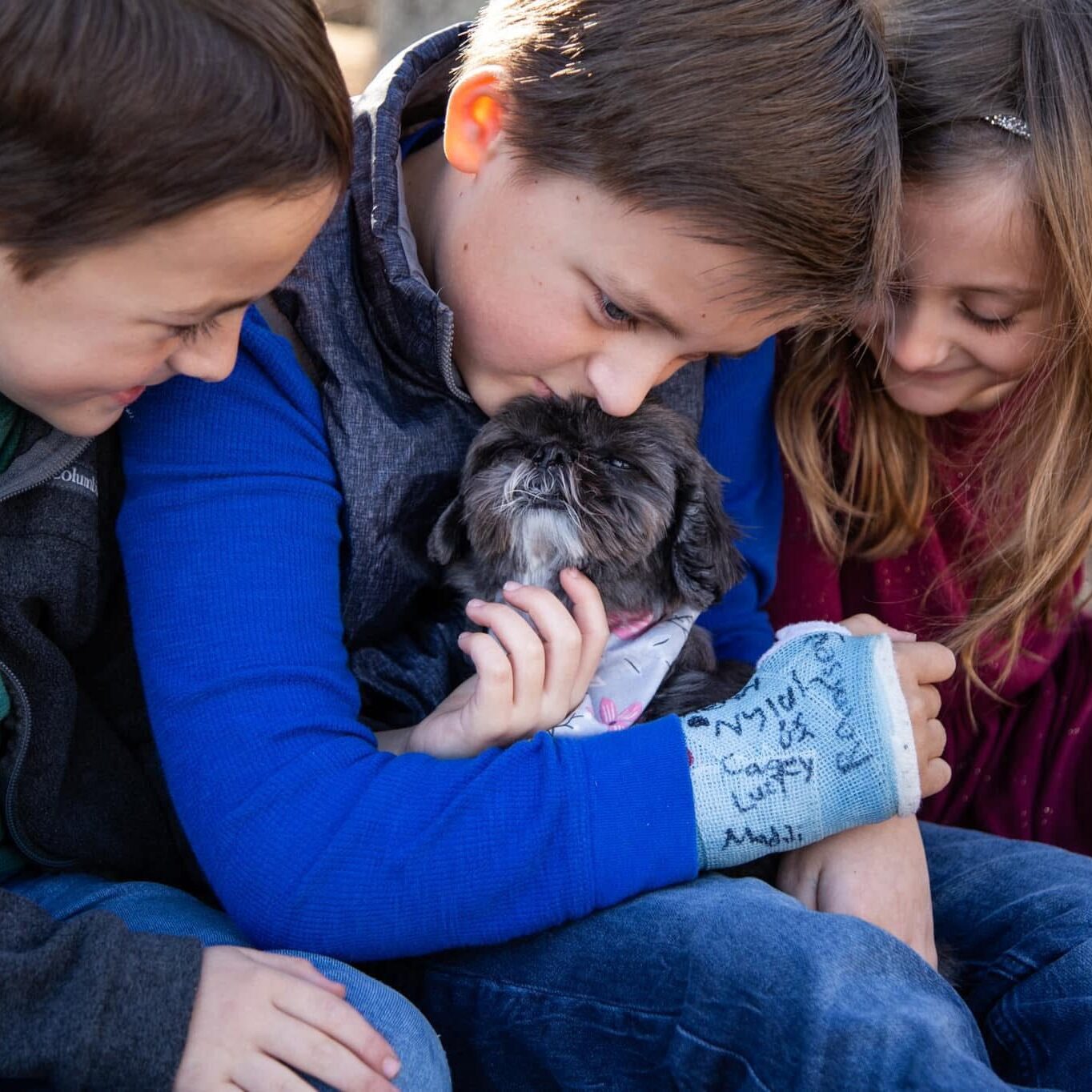 children petting their senior dog